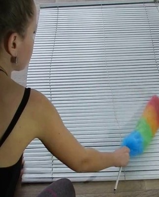 the process of cleaning blinds with a brush