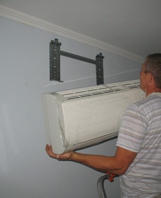 a man holding an air conditioner