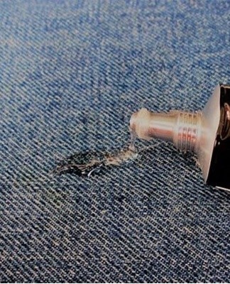 Softened glue is collected with a napkin, clothes are washed off.