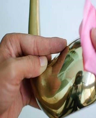 Citric acid granules are sprinkled on the brass coating and rubbed vigorously into the contaminated areas.