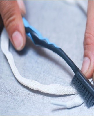 You need to wet the laces, apply toothpaste to them and distribute it evenly with a brush
