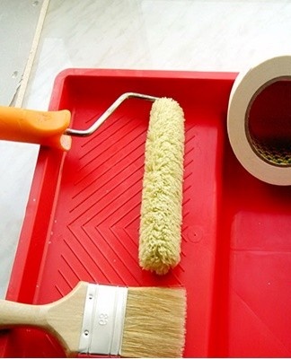 The brush is dipped in the paint by a third, then pressed against the edge of the container to remove the excess.