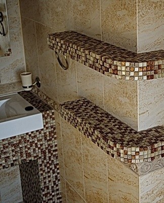 There is a huge selection of materials for tiling the bathroom with mosaics, the cost of which depends on the quality characteristics.