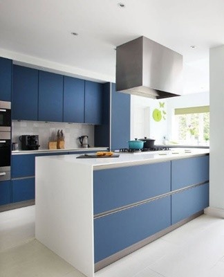 The kitchen looks stylish, where the dark blue facades of the cabinets coexist with the snow-white walls, a counter and an apron.