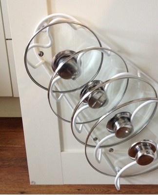 Storing lids with pans always wastes space, so racks can be fitted inside cabinet doors.