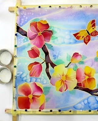 To perform this type of painting, the T-shirt must be pulled over the frame and treated with liquid dyes.